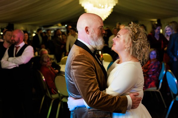 bride and groom dance on the dancefloor smiling at each other