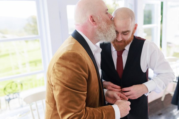 groom kisses groomsman on the head