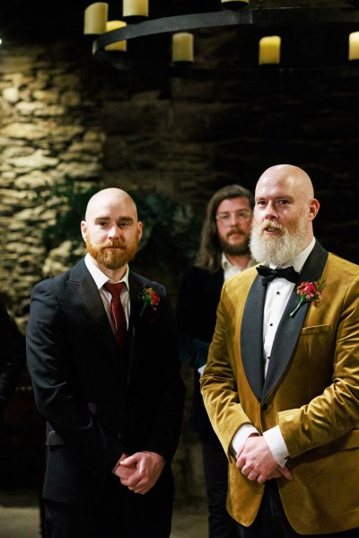 groom and groomsman stand at the alter