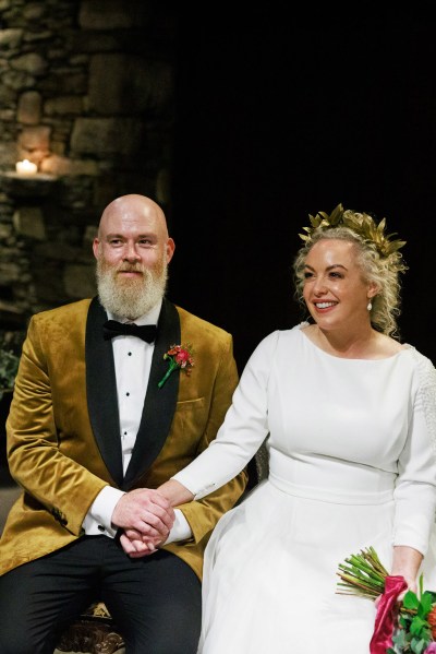 bride and groom sit at the alter on chairs