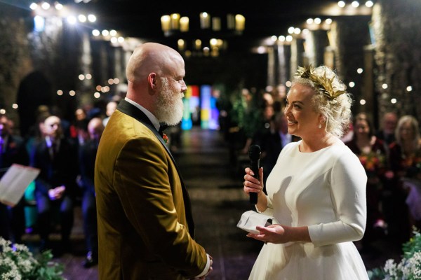 bride reads her vows out to groom at alter