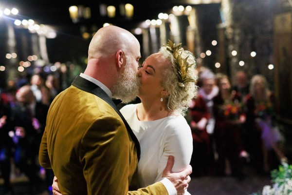 bride and groom kiss at alter