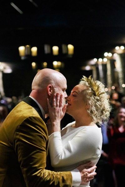 bride and groom kiss at alter