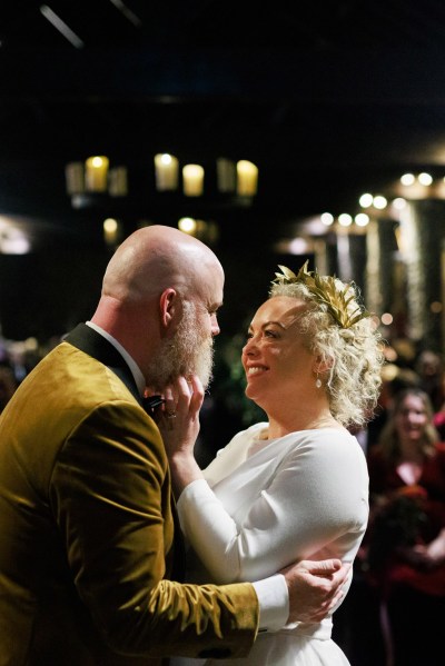 bride and groom embrace and look at each other at alter