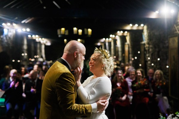 bride and groom embrace and look at each other at alter