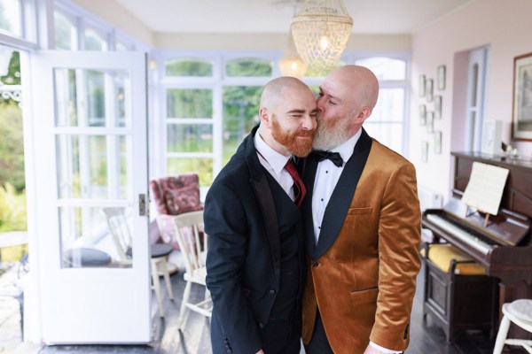 groom kisses groomsman on the cheek