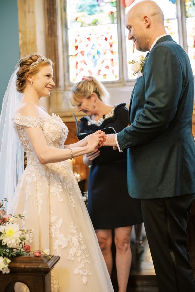 bride and groom hold hands at alter setting with celebrant