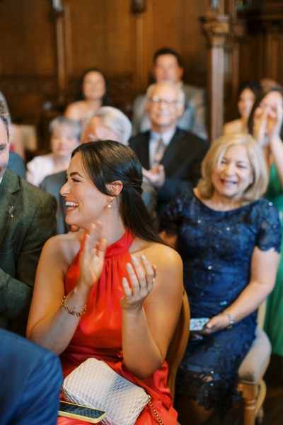 woman in audience clapping for bride and groom