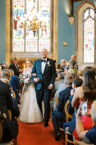 bride and groom exit ceremony setting with guests clapping