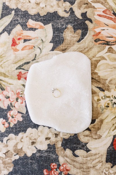 close up of the floral design on Victorian sofa chair and wedding ring placed in handkerchief