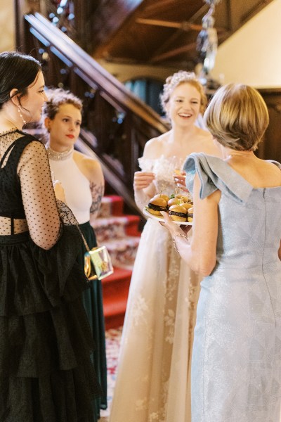 bride and mother chatting beside staircase