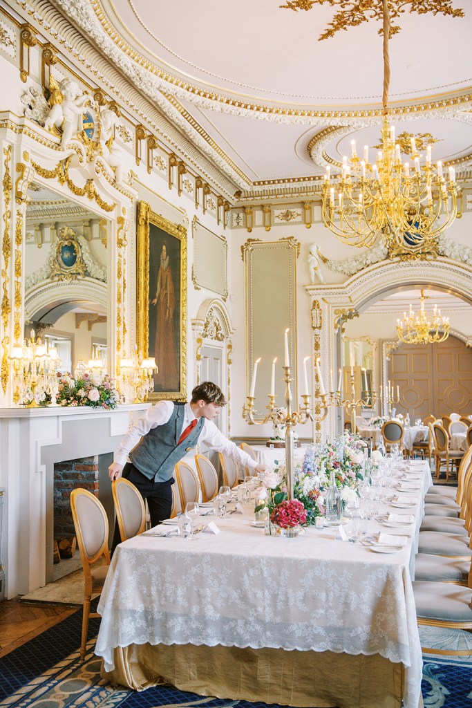 waiter fixes up the decor on dining room table