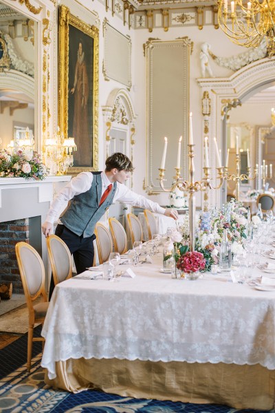 waiter fixes up the decor on dining room table