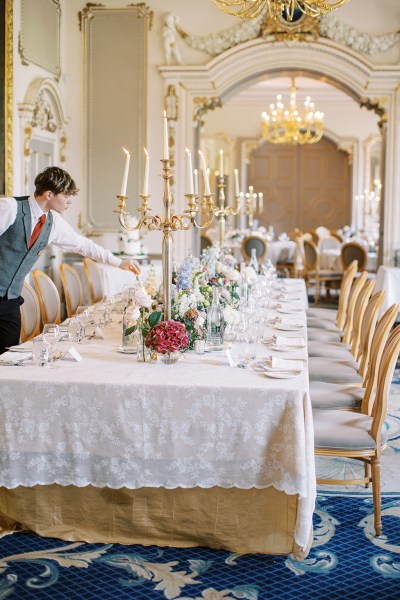 waiter fixes up the decor on dining room table