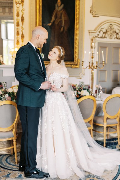 bride and groom look at each other in the interior dining room stately room