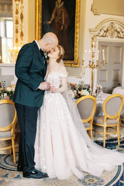 bride and groom kiss interior dining room stately room