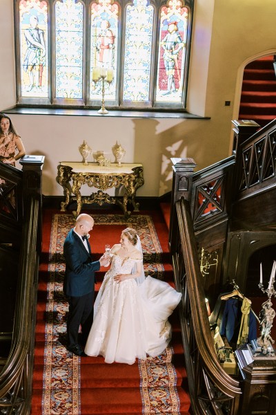 bride and groom on the staircase to wedding venue they walk up the steps