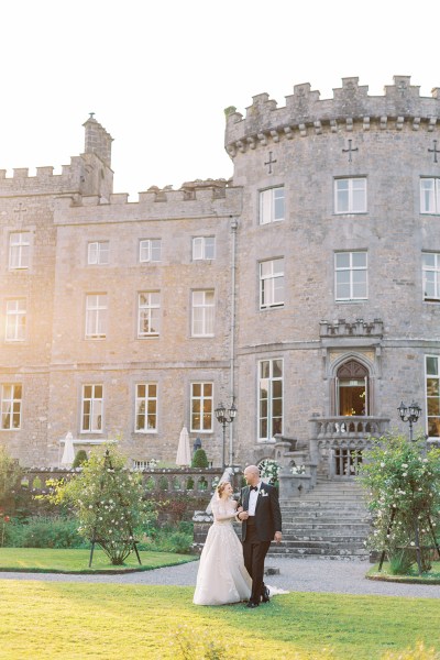 bride and groom wide shot of castle venue in background