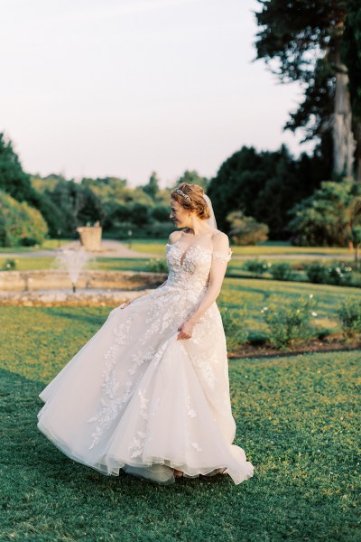 bride standing in garden trees fountain sun setting she dances