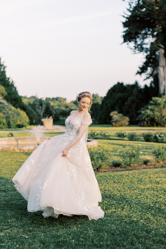 bride standing in garden trees fountain sun setting she dances