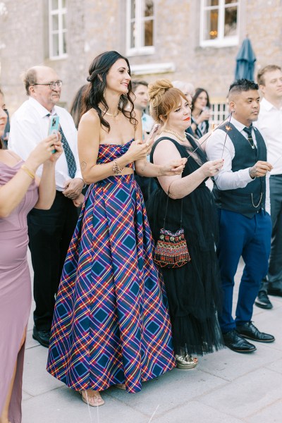 guests clap as they watch couple dance in courtyard