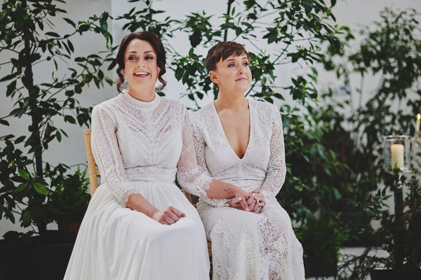 Brides sit at top of alter in front of guests