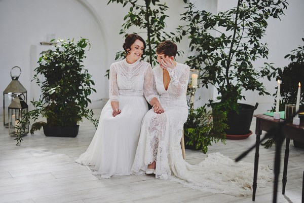 Brides sit at top of alter in front of guests