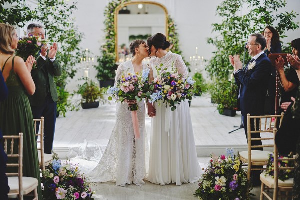 Brides kiss at the alter