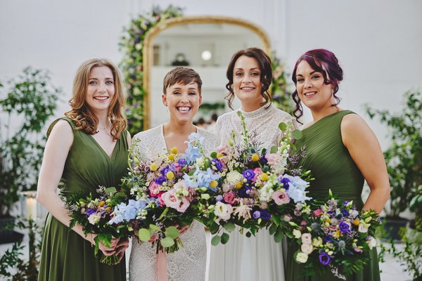 Brides and bridesmaids in green holding bouquet