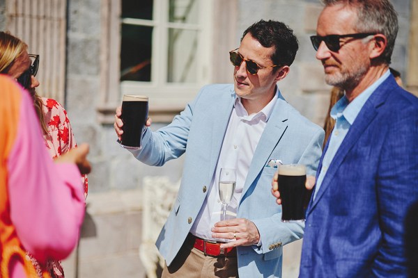 Men hold cups of Guinness