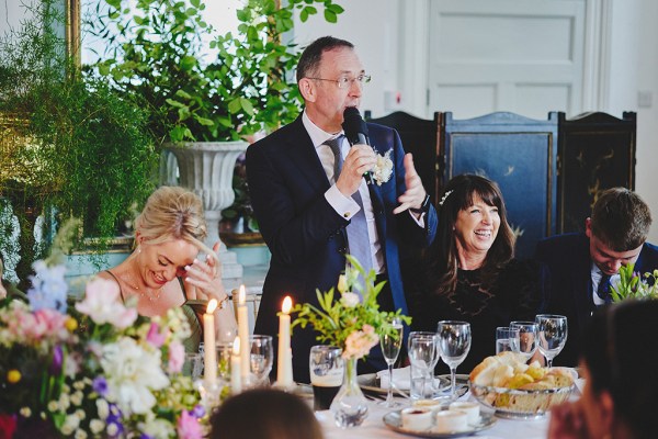 Man in suit gives speech at table father