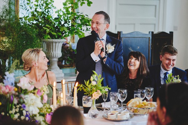 Man in suit gives speech at table