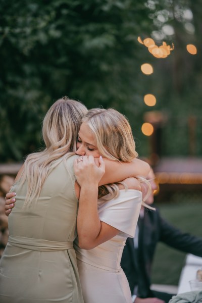 bridesmaid and bride hug