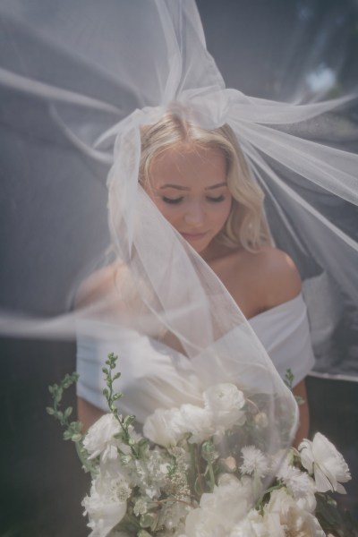 bride has veil covering her face