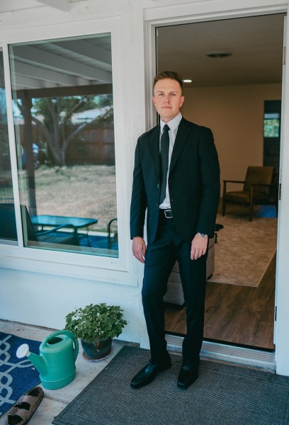 groom is ready as he stands at house door entrance