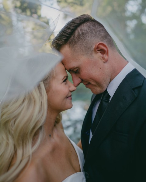 bride and groom laughing as they touch foreheads