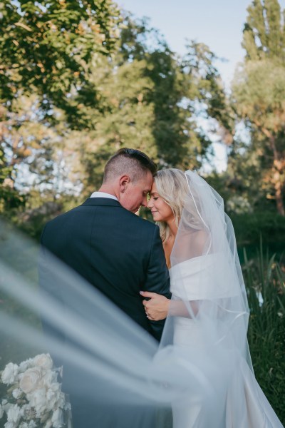 bride and groom touch foreheads smiling and looking down