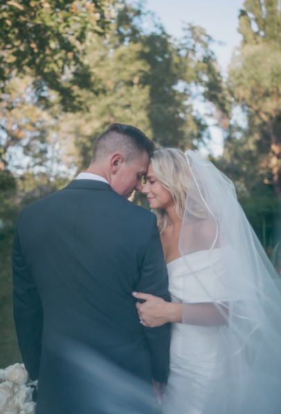 bride and groom touch foreheads smiling and looking down