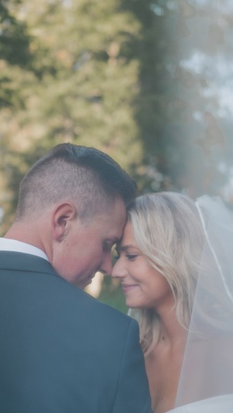 bride and groom touch foreheads smiling and looking down