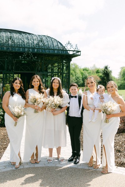 Bridesmaids and little boy in the middle wearing suit