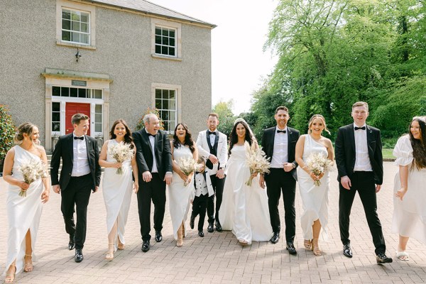 Family portrait of bridesmaids groomsmen bride and groom outside venue