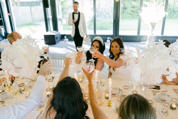 Bride cheers at the table with bridesmaids