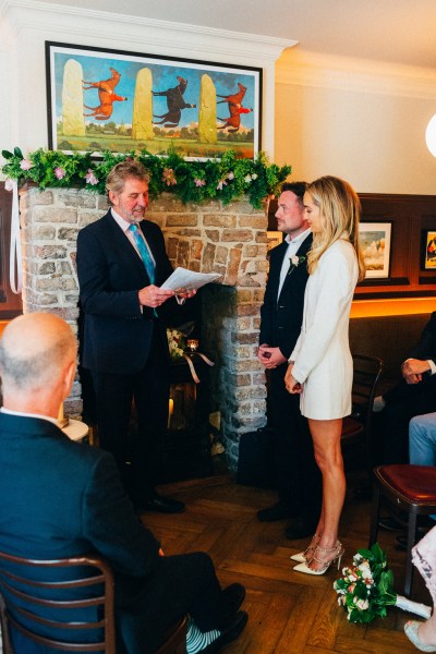 bride groom and celebrant at alter setting wedding