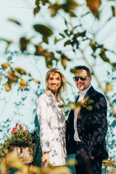 bride and groom stand and pose smiling in garden forest setting