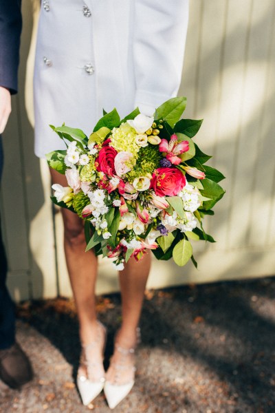 close up of bouquet bride is holding in front of wall