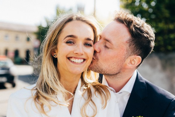 groom kissing bride on the cheek