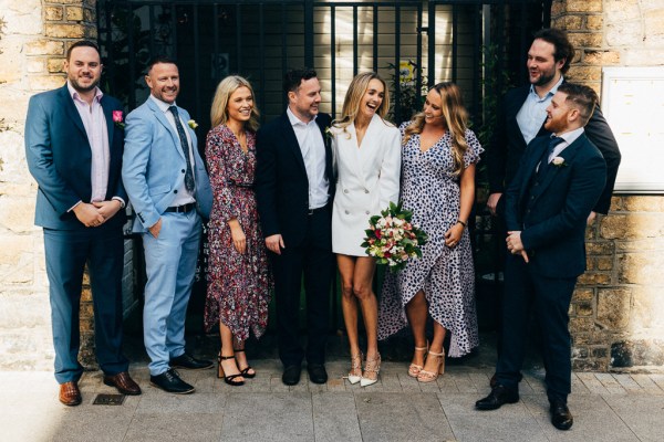 bride and groom in the middle of friends and family members