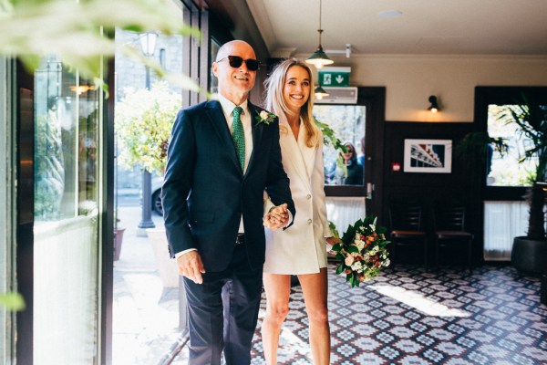 bride and groom walk into venue all smiles