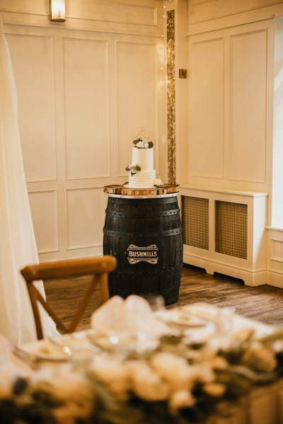 white wedding cake sitting on barrel