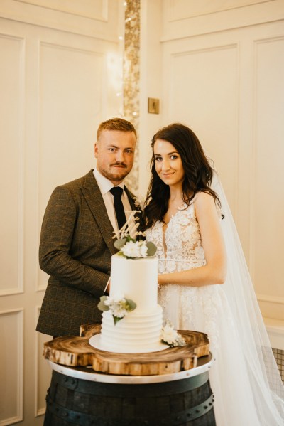 bride and groom cutting the white wedding cake